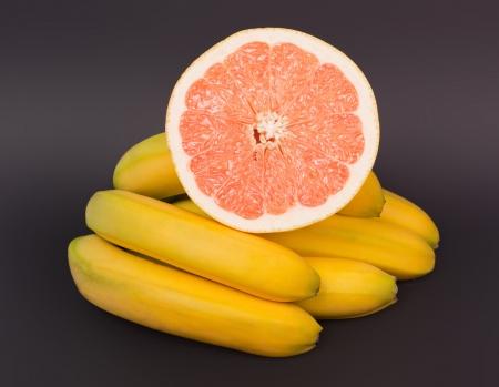 grapefruit and banana on black backgroundの写真素材