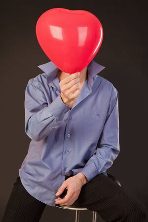 guy holds a balloon in the form of heartの写真素材