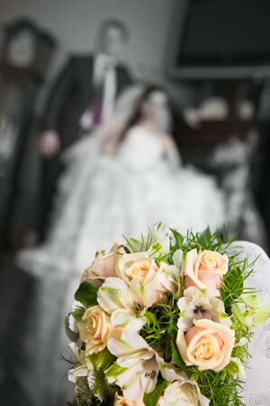 Wedding bouquet with the wedding couple in the backgroundの写真素材
