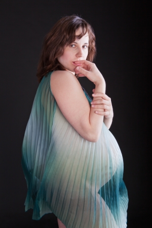 Nude lady with big belly in a transparent sundressの写真素材