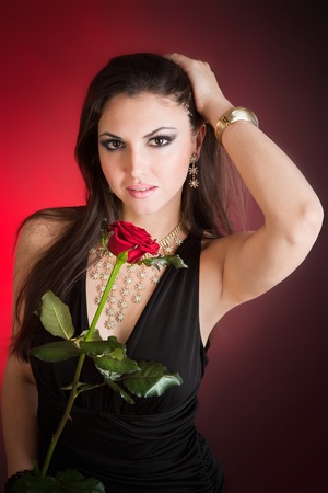Portrait of young beautiful woman in little hat and rose in her hands の写真素材