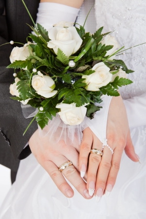 Hands with rings and wedding bouquetの写真素材