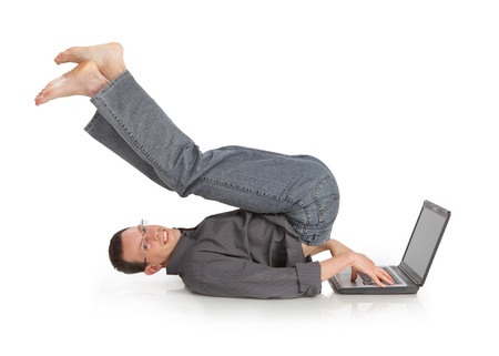 flexible cheerful guy with the laptop isolated on a white backgroundの写真素材