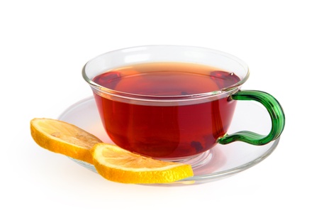 Tea with a lemon in a glass cup isolated on a white background  Black tea in a glass cup and on a saucer two slices of a lemonの写真素材