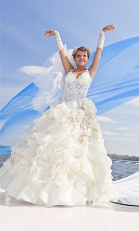 The beautiful bride on the yacht in solar and bright day in the blue skyの写真素材