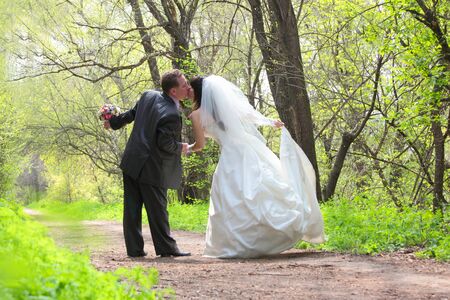 bride and groom kissing in the parkの写真素材