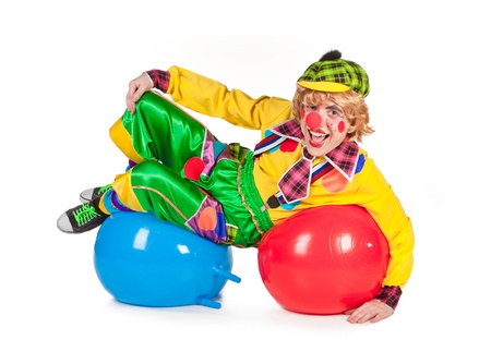 Funny clown lies on balls isolated on white backgroundの写真素材
