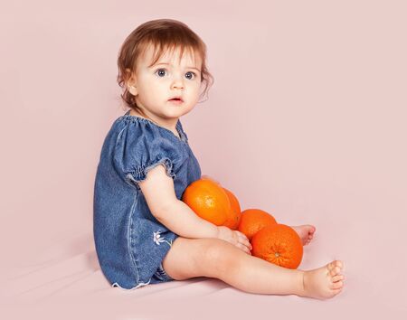 little beautiful girl with much orangesの写真素材