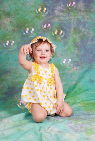 little funny girl with soap bubbles in studioの写真素材