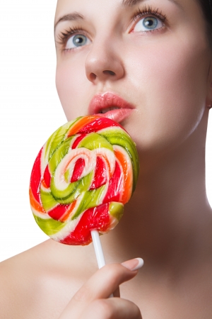 multi-coloured candy on the lips of a girl close up isolated on a white backgroundの写真素材