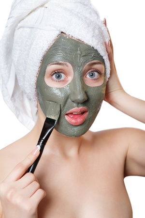 Young woman with facial mask in beauty spa isolated on a white backgroundの写真素材