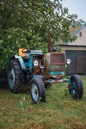 Old abandoned rusty tractor in villageの写真素材