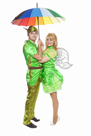 couple in fancy dresses under an umbrella isolated on a white backgroundの写真素材