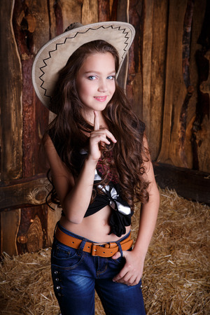 beautiful cowgirl style model posing on farmland near hayの写真素材