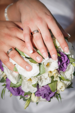 Hands and rings on wedding bouquetの写真素材