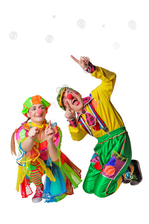 Two cheerful clowns in the soap bubbles isolated on a white backgroundの写真素材