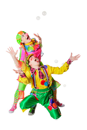 Two cheerful clowns in the soap bubbles isolated on a white backgroundの写真素材