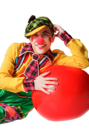 Funny clown lies on red ball isolated on white backgroundの写真素材