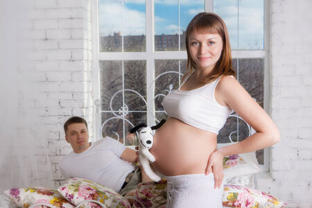 Pregnant woman with her husband at homeの写真素材