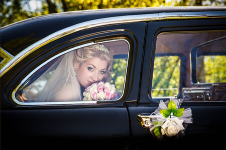 Portrait of the bride in a window of a wedding retro of the carの写真素材