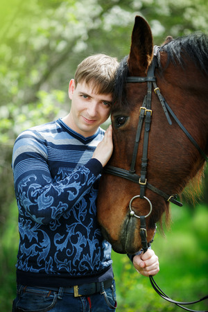 Portrait of the man near a brown horseの写真素材