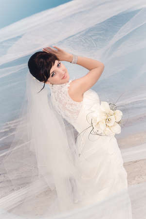 Portrait of beautiful bride standing by the beachの写真素材