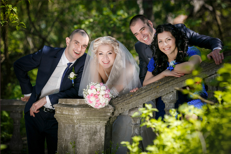 Portrait of the groom, the bride and the best man with the witness in the parkの写真素材