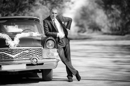 groom  stand near a black retro of the carの写真素材
