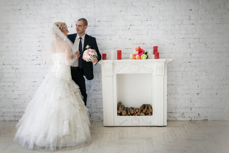beautiful bride an groom on their wedding day near fireplaceの写真素材