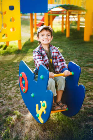 Happy games - pretty boy in cap on the playgroundの写真素材