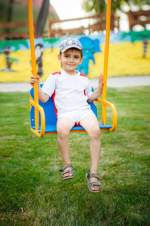 happy child swinging on a swingの写真素材