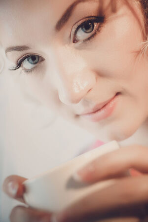 Close up face of the bride with a cup of coffee in the handsの写真素材