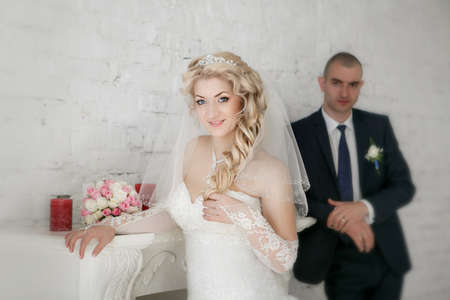 beautiful bride an groom on their wedding day near fireplaceの写真素材