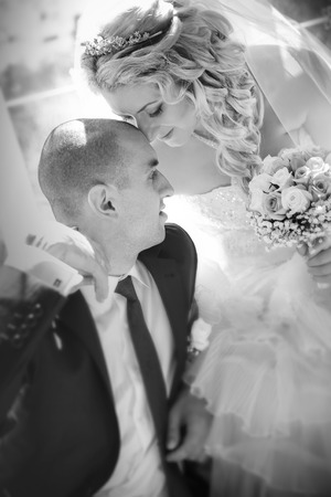 happy groom and the bride sit at a windowの写真素材