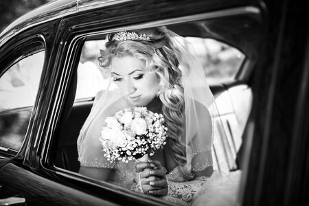 Portrait of the bride in a window of a wedding retro of the carの写真素材