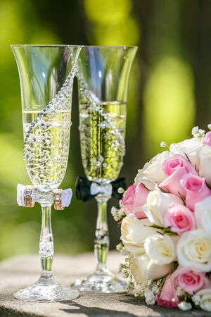 Wedding rings with roses and glasses of champagneの写真素材