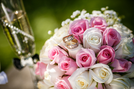 Wedding rings with roses and glasses of champagneの写真素材