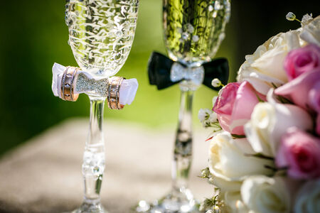 Wedding rings with roses and glasses of champagneの写真素材