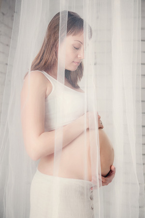 Beauty and sexy of young pregnant woman with blowing white materialの写真素材