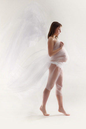Beauty and sexy of young pregnant woman with blowing white materialの写真素材