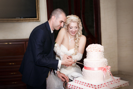 Bride and groom cutting the wedding cakeの写真素材