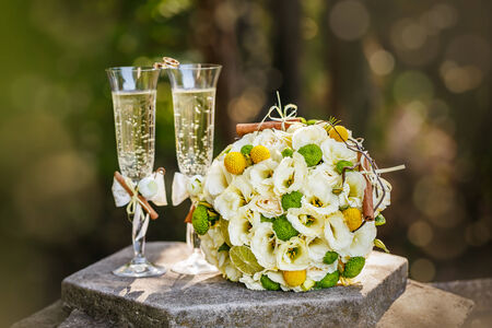 Wedding rings with roses and glasses of champagneの写真素材