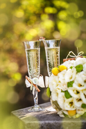 Wedding rings with roses and glasses of champagneの写真素材