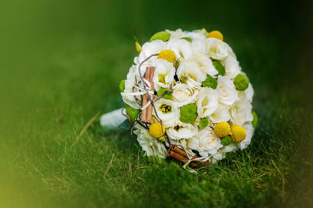 Wedding bouquet from beige roses, cinnamon, a lemon, a lime on a green grassの写真素材