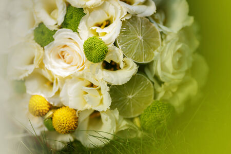Wedding bouquet from beige roses, cinnamon, a lemon, a lime on a green grassの写真素材