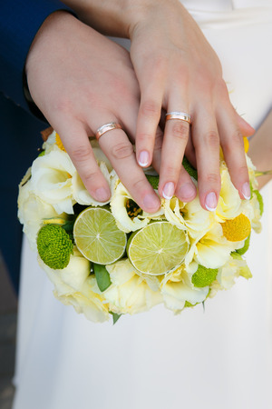 Wedding bouquet in hands of the bride and groomの写真素材