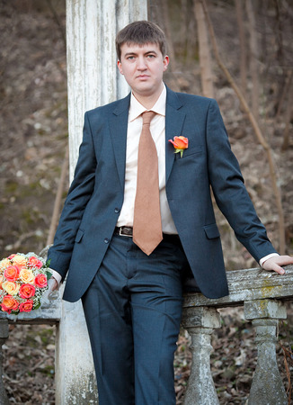 well-dressed groom standing near columnの写真素材