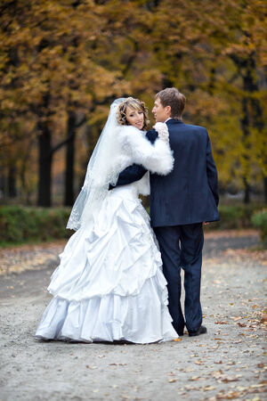 the groom and the bride on walk in park in autumn dayの写真素材