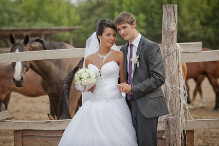 groom and  bride  stand near the horse shelterの写真素材