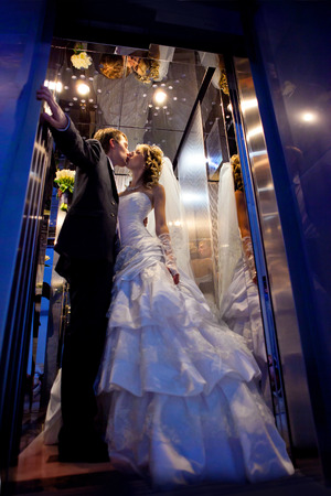 Kiss of the groom and the bride in the hotel elevatorの写真素材